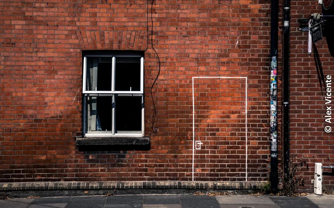 Window and geometric marks on a brick wall